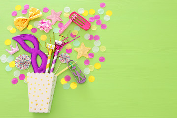 Purim celebration concept (jewish carnival holiday) over green wooden background. Top view. Banner.