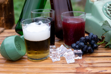 grape wine and draft beer in glass on Chair made of bamboo

