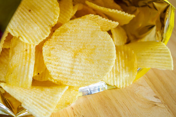 potato chips open bag on wood table
