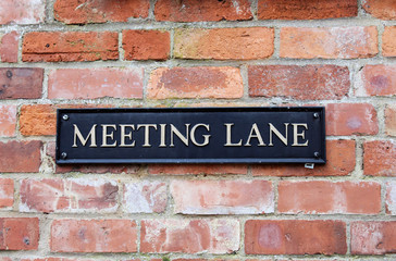 Meeting Lane sign on brick wall