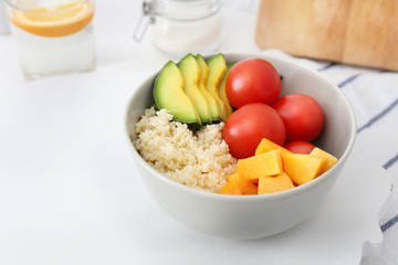 Bowl with porridge and fresh vegetables on table. Diet food