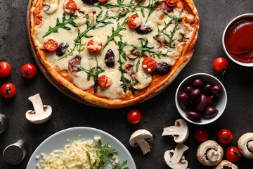Delicious pizza and ingredients on table