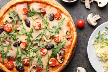 Delicious pizza and ingredients on table