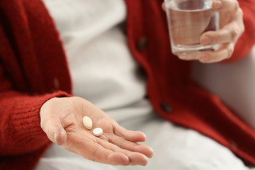Elderly woman taking pills, closeup