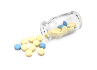 Glass bottle with pills on white background