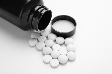 Bottle with pills on white background