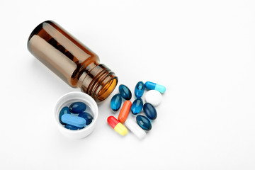 Glass bottle with pills on white background