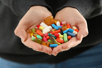 Woman with handful of different pills, closeup