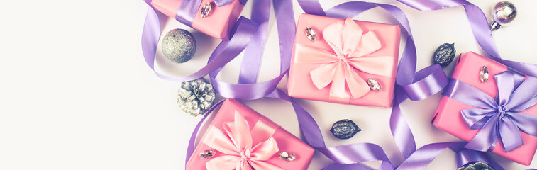 Banner Christmas boxes with gifts on the occasion of pink color on white background cones nuts decor Top view flat lay horizontal Selective focus