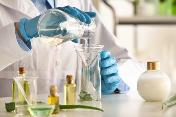 Woman making organic cosmetics with aloe in laboratory