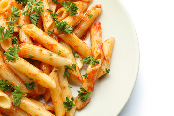 Plate with tasty penne pasta on white background