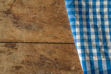 Blue and white checkered napkin on vintage wooden background with copy space