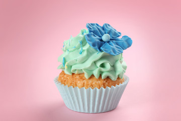Tasty cupcake on color background