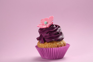 Tasty cupcake on color background