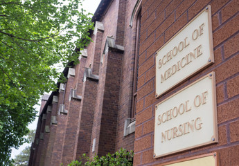 School of medicine and school of nursing sign on red brick wall building.