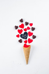 Ice Cream or Cone with Chocolate Candy and Red Hearts on white Background. Top View. Love or Valentine's Day Concept. Top view, flat lay