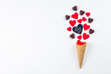 Ice Cream or Cone with Chocolate Candy and Red Hearts on white Background. Top View. Love or Valentine's Day Concept. Top view, flat lay