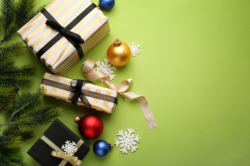 Beautiful Christmas decorations with gift boxes on color background