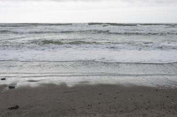 Water raws, sky, sand and stones in La Push beach area, WA