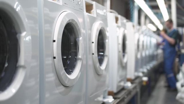 Production of household appliances, conveyor, master at work, part assembly process of element washing machine boddies.