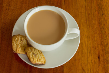 tea with biscuits in white tea cup on wooden table 