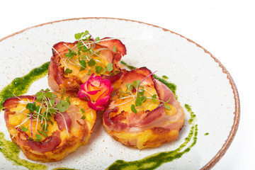 plate of bacon wrapped scallops in neat rows on a light colored plate