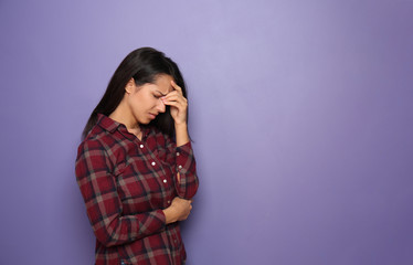 Stressed young woman on color background