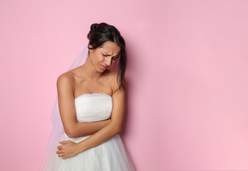 Obraz na płótnie Canvas Stressed young bride on color background
