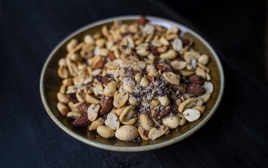 Peanuts nuts in a bowl on a dark background.