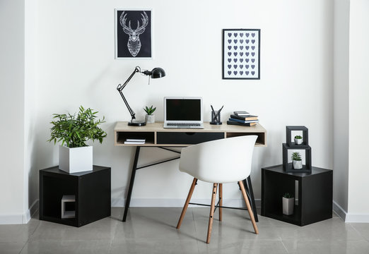 Stylish workplace with laptop in room