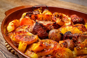 Stew with homemade smoked meat and vegetables in ceramic bowl. Sweet and plain potato, carrot, champignon mushrooms garlic and onion.