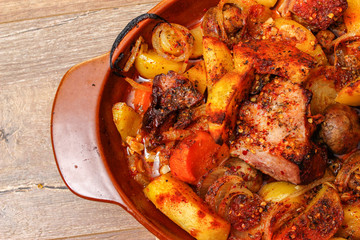 Stew with homemade smoked meat and vegetables in ceramic bowl. Sweet and plain potato, carrot, champignon mushrooms garlic and onion.