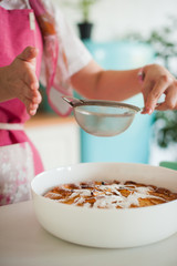 Pouring sugar powder on homemade apple pie