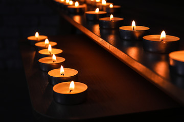Burning candles on table in darkness