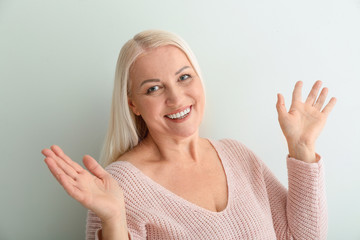 Portrait of beautiful mature woman on light background