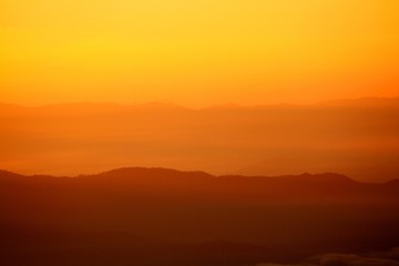 Fototapeta na wymiar Beautiful orange sunlight or sunrise in morning with silhouette of big mountain for background at Doi Chiang Dao, Doi Luang Chiang Dao, Chiangmai, Thailand -Landmark and Beauty of Nature concept