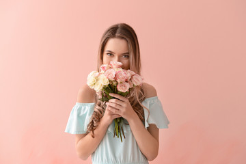 Beautiful young woman with bouquet of flowers on color background