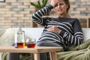 Pregnant woman drinking alcohol at home