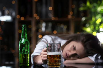 Depressed woman drinking alcohol in bar