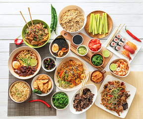 Assortment of Chinese food on white wooden table