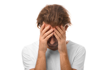 Fototapeta premium Young man suffering from headache on white background
