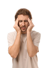 Naklejka premium Young man suffering from headache on white background