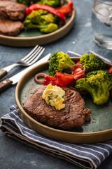 Grilled Beef steak with garlic butter and vegetables. Meat with grilled bell pepper, broccoli and onions.