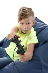 Emotional boy playing video game on white background