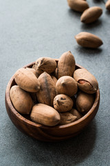 Pecan Nuts with Shell in Wooden Bowl / Walnuts.