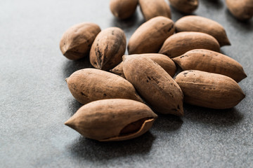 Pecan Nuts with Shell in Wooden Bowl / Walnuts.