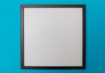 White blank empty board with black frame, blue wall background, copy space