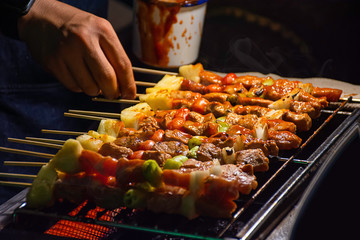 BBQ grilled meat with vegetables and tomato sauces on the steel grilles With the heat.