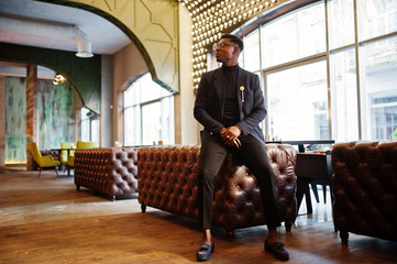 Obraz na płótnie Canvas Fashionable african american man in suit and glasses posed at cafe.