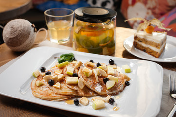 New Year's breakfast. Fritters with fruit, berry tea and cake.